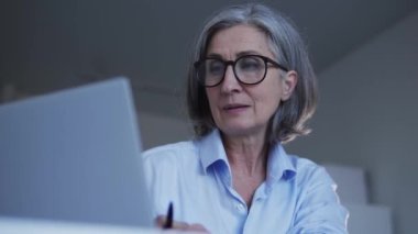 Bayan öğretmen laptop 'da online dersler veriyor. Öğrencilerin bağlantısını bekliyor.