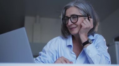 İş kadını laptopta e-posta okuyor ve gülümsüyor, komik teklifler alıyor.