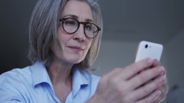 Şık Gözlüklü Çekici Kadın Akıllı Telefondan Sosyal Ağlarda Sohbet Ediyor — Stok video