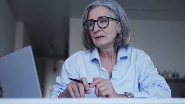 Gri Saçlı Kadın Piyasa Araştırmacısı Dizüstü Bilgisayardaki Verileri Inceliyor Gözlüklerini — Stok video