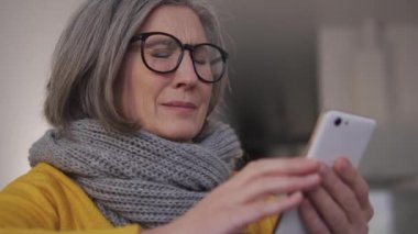 Üst düzey kadın gözlüklü, baş ağrısı ve yorgunluk hisseden, baş ağrısı çeken, akıllı telefon üzerinde çalışan, aşırı çalışan, duygusal çöküntüler, yüksek tansiyon