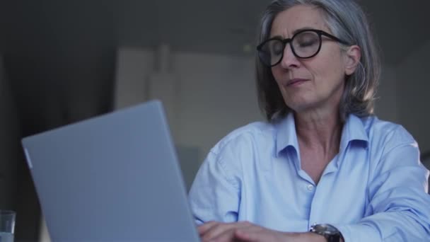 老年妇女在笔记本电脑上工作时感到脖子疼痛 久坐不动的生活方式问题 — 图库视频影像