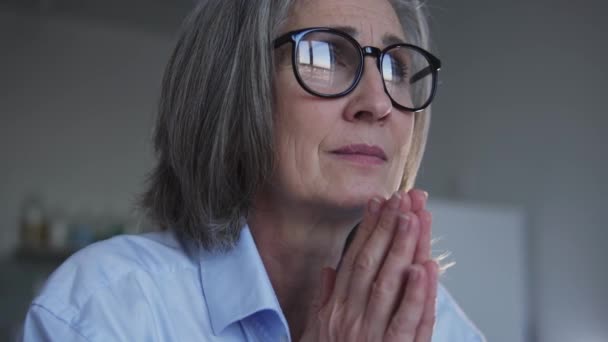 灰色の髪を持つ深い宗教的な成熟した女性は一緒に手を押し 目を閉じて 神を祈り 祝福と保護を求め 新しい日と機会をありがとうございました — ストック動画