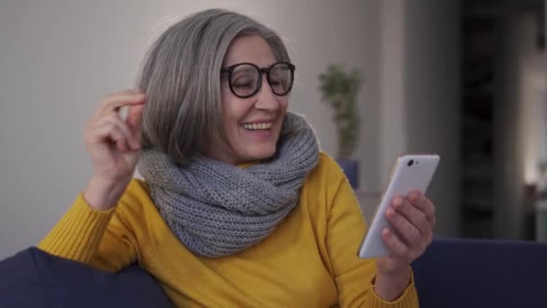 Senior Mujer Elegante Disfrutando Música Teléfono Inteligente Bailando Sentado Sofá — Vídeo de stock