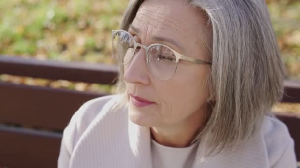 Mulher Madura Atraente Óculos Moda Sentado Banco Parque Sentindo Nervoso — Vídeo de Stock