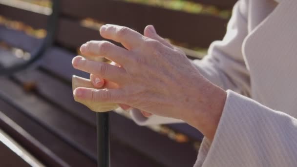成熟的残疾妇女看着颤抖的 皱巴巴的手 靠在手杖上 — 图库视频影像