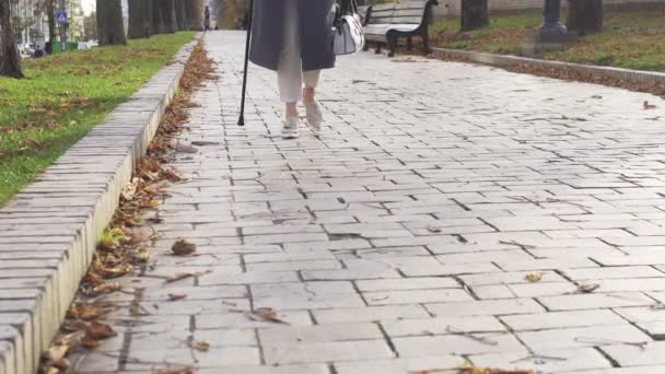 Элегантная Женщина Медленно Движется Аллея Опираясь Трость Ортопедические Ботинки — стоковое видео