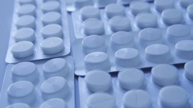 Kabarcıklardaki bir sürü tablet masanın üzerinde dönüyor, uyuşturucu kaçakçılığı, ülkeye yasadışı uyuşturucu ithalatı, ruhsatsız veya sahte ilaçlar, uyuşturucu kaçakçılığı