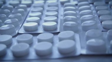 Tabletleri masada duran beyaz kabarcıklar, mevcut uyuşturucu analoglarının klinik denemeleri, aktif bileşenler ve plasebo içeren paketler, risk grubu