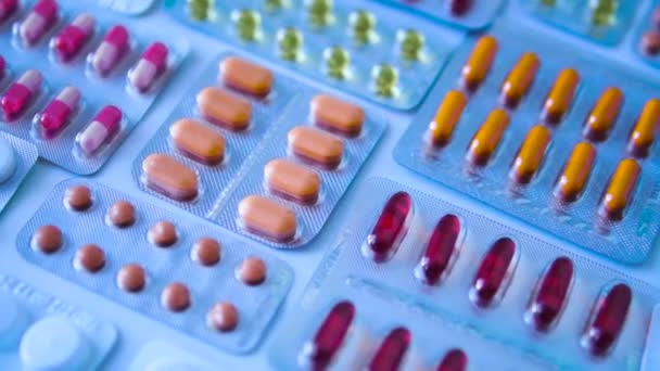 机の上に横たわる薬剤水疱の多くの色の錠剤 抗菌薬 抗ヒスタミン薬や抗ウイルス薬の大規模な選択 寒い季節のための準備 — ストック動画