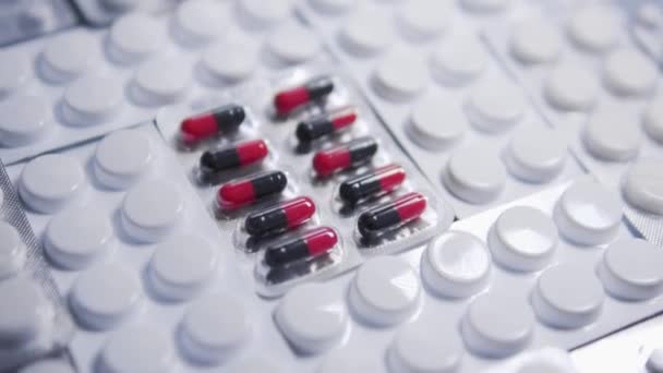 Fehér Buborékfóliák Között Fekvő Piros Fekete Tabletták Tablettákkal Asztalon Rákgyógyszerekkel — Stock videók