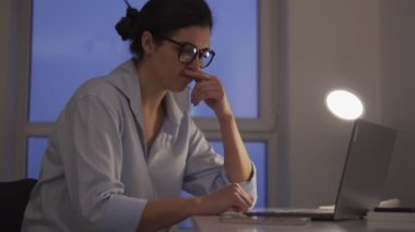 Kadının dizüstü bilgisayarla ilgili problemleri var. Görevleri tamamlamayı bekliyor.