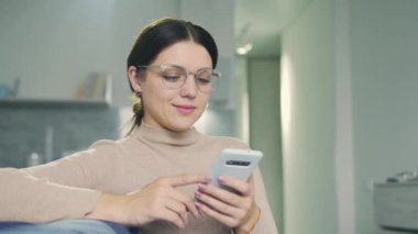 Pozitif kadın otobüste dinlenirken ve akıllı telefondan video izlerken eğleniyor.