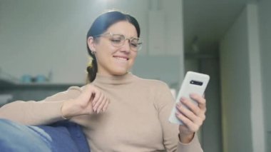Mutlu pozitif kadın akıllı telefonuyla en iyi şarkıları yapmaktan hoşlanıyor, aktif olarak müziğin ritmine ayak uyduruyor, müzik kanalına abone oluyor, tercihlerinize dayalı şarkılar seçiyor.