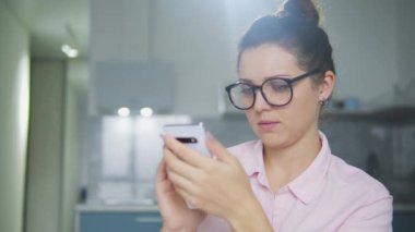 Gözlüklü kafası karışmış bir kadın cep telefonu ekranına bakıyor. Yanlışlıkla kişisel verileri ağa yüklüyor. Uzun açılış hatası.