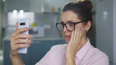 İnek kız akıllı telefon ön kamerasında flört sitesi için selfie çekmeye çalışıyor.