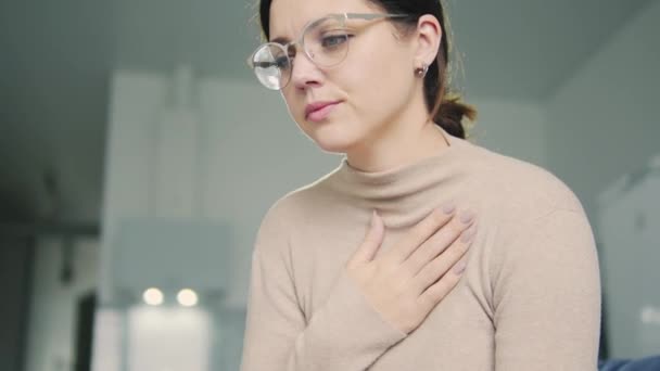 Mujer joven con tos fuerte y tacto en el pecho mientras tose, sensación de dolor en el pecho, riesgo de inflamación pulmonar o bronquitis, síntomas de covid-19 — Vídeos de Stock