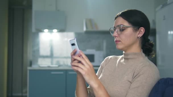 Hezká mladá žena chatování s přítelem na smartphone a usmívání, flirtování — Stock video