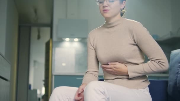 胆石症を患っているブルネットの女性,痛みで顔をしかめる胃の痛みに触れる — ストック動画