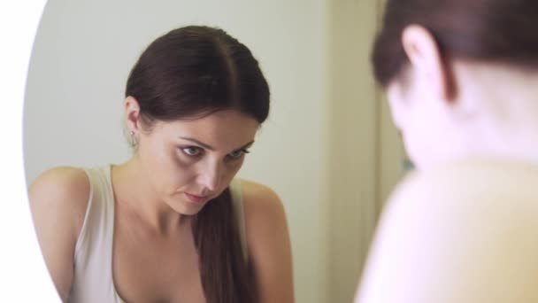 Απελπισμένη θλιμμένη γυναίκα στέκεται στο μπάνιο και προσπαθεί να δει την αντανάκλασή της. — Αρχείο Βίντεο