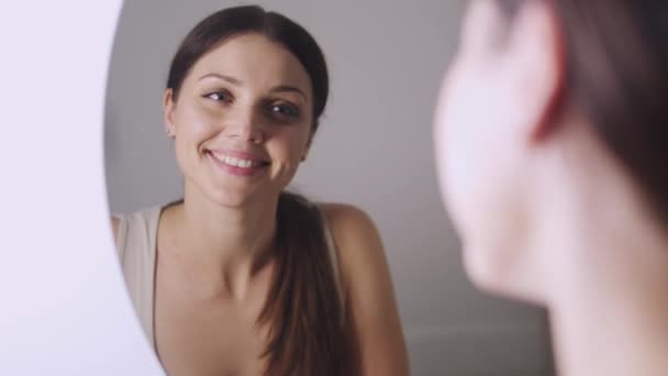 Счастливая Позитивная Молодая Женщина Глядя Свое Отражение Зеркале Стоящем Ванной — стоковое видео