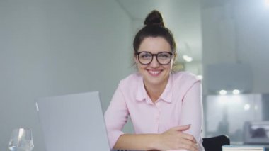 Ünlü derginin kadın editörü iş yerinde dizüstü bilgisayarla gülümsüyor ve poz veriyor.