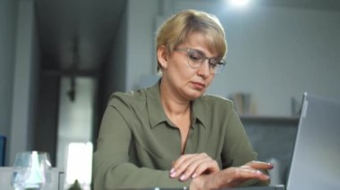 Gözlüklü bir iş kadını dizüstü bilgisayarda yazıyor, e-postaları kontrol ediyor, kötü haberlerle mektup alıyor, iş piyasasında yeni bir rakip, şirket hisselerinin düşmesi, kriz, evden çalışma