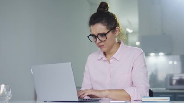 穿着时髦眼镜和工作服的疲倦的女职员在笔记本电脑上工作时打呵欠 因早起和晚睡而感到精疲力竭 单调的工作 — 图库视频影像
