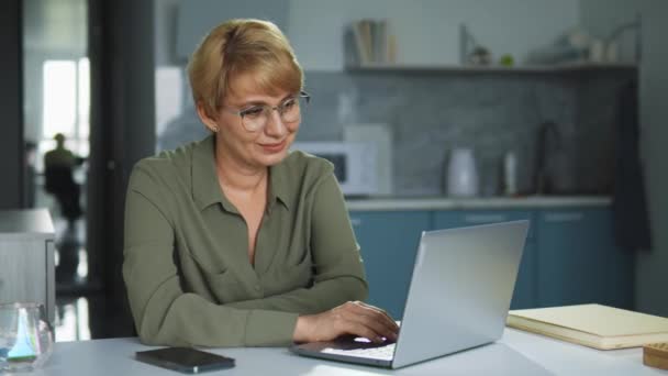 Gözlüklü Elbiseli Güzel Bir Kadın Laptopta Evden Çalışıyor Iltifatlarla Mesajlar — Stok video