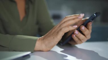 Kadın akıllı telefondan web sayfalarını karıştırıyor, banka hesabını kontrol ediyor, internetten alışveriş yapıyor.