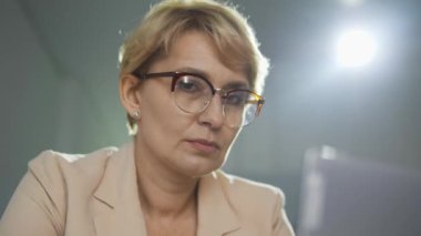 Gözlüklü kadın ofis işinden sıkılmış ve temiz hava almayı hayal ediyor.