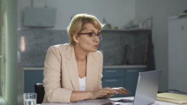 Heyecanlı, iş elbisesi giymiş pozitif bir kadın aktif olarak müzik ritmine ayak uyduruyor, radyo programında en sevdiği şarkıyla dans ediyor, evden çalışıyor, iş sırasında mola veriyor.