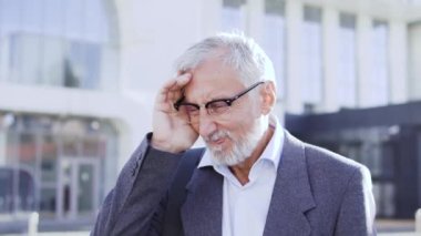 Yorgun, olgun bir adam baş ağrısı çekiyor, dışarıda tapınağa masaj yapıyor.