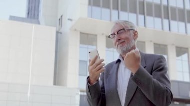 Yakışıklı son sınıf öğrencisi dans ediyor, akıllı telefonuyla iyi haberlerin tadını çıkarıyor, bir kadını randevuya davet ediyor ve olumlu bir cevap alıyor, şansı ve başarısı ile tatmin oluyor, pozitifliği...