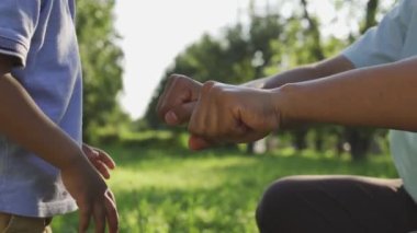 Çocuk babasının elinde bir şey arıyor, baba numara yapıyor, oğluyla oynuyor.