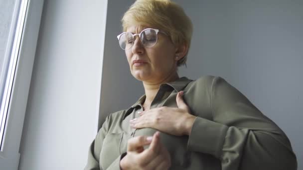 Žena Středního Věku Brýlích Mračí Pocitem Bolesti Hrudi Masíruje Prsa — Stock video