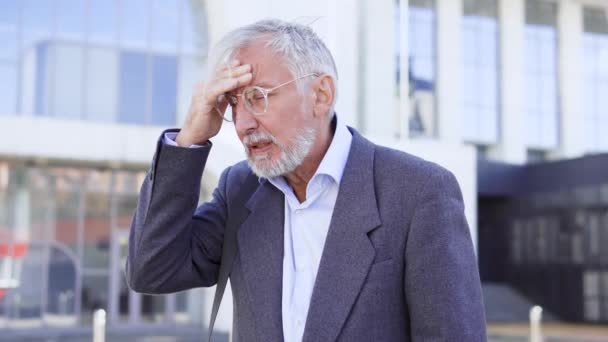 Starszy Mężczyzna Okularach Odczuwa Ból Głowy Spacerując Miejskich Naczyniach Krwionośnych — Wideo stockowe