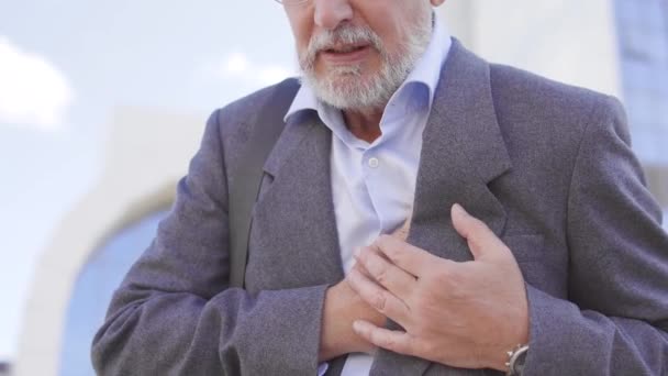 成熟したビジネスマンが突然胸に触れ痛みや心臓発作で顔をしかめる — ストック動画