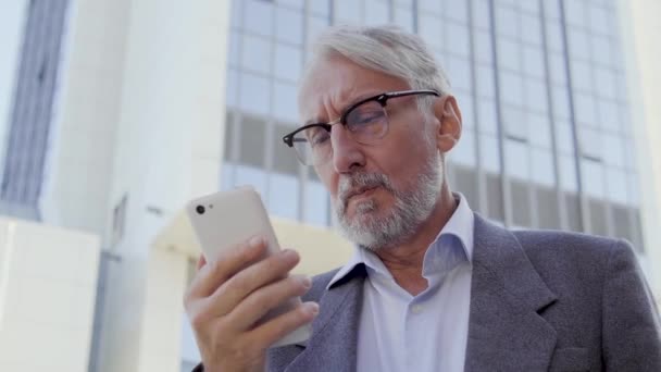 Starší Muž Čte Zprávy Smartphone Myšlení Nad Situací Přijímání Rozhodnutí — Stock video