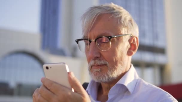 戴眼镜的大胡子男子在户外用智能手机查看自己的银行账户 — 图库视频影像