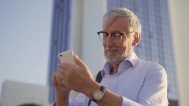 Lachende Positieve Senior Man Kijken Naar Foto Smartphone Genieten Van — Stockvideo