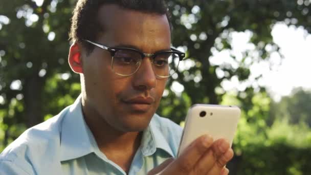 Багатоетнічний Красивий Чоловік Окулярах Усміхнений Смс Додатку Messenger Смартфоні — стокове відео