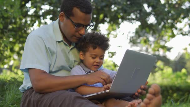 Pai Multiétnico Tentando Trabalhar Laptop Com Pequeno Filho Cabelos Encaracolados — Vídeo de Stock