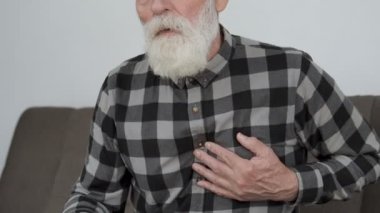 Yalnız, hasta büyükbaba göğsünde şiddetli bir ağrı hissediyor, elini kalbine koyuyor, felç geçiriyor.