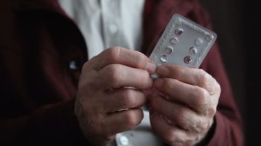 Yaşlı adam su toplamasından, hastalığın tedavisinden, sağlık hizmetlerinden, teşhisten hap alıyor.