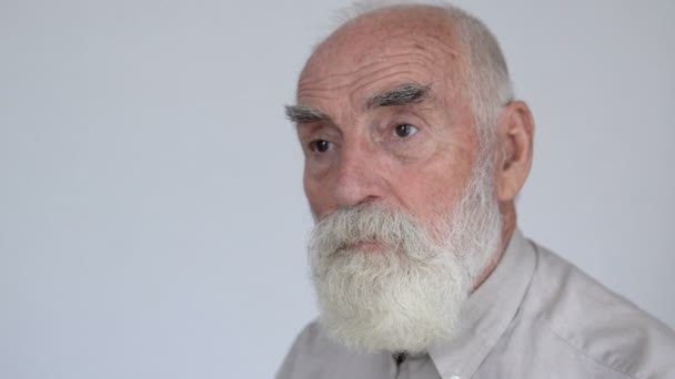 灰色のひげを持つ悲しい老人孤独な一点を見て座って 老人の不完全 — ストック動画