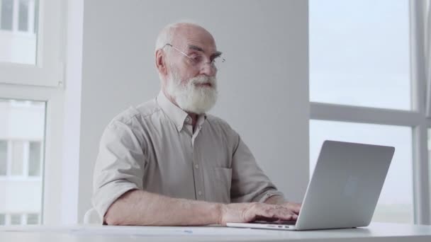 Σοβαρός Γέρος Δακτυλογραφεί Φορητό Υπολογιστή Κάθεται Στο Άδειο Γραφείο Ξεκινώντας — Αρχείο Βίντεο