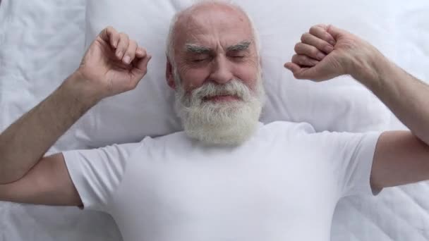 高兴的白发苍苍的养老金领取者躺在床上 躺在舒适的枕头上醒来 — 图库视频影像