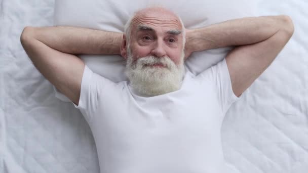 ベッドに横たわっインスピレーションを受けた高齢者 創造的なアイデア 家の快適さ 自由な時間でリラックス — ストック動画