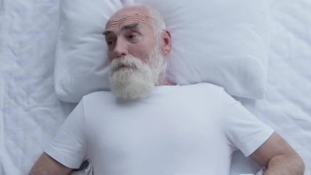 Ενοχλημένος Γέρος Ξυπνάει Ξαφνικά Στο Κρεβάτι Και Υποφέρει Από Θόρυβο — Αρχείο Βίντεο